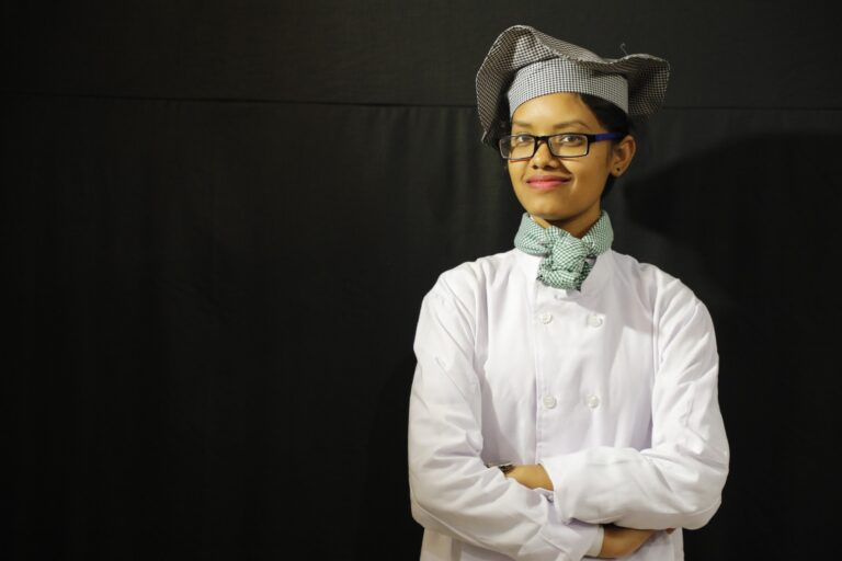 A hospitality trainee in chef uniform during a practical learning activity