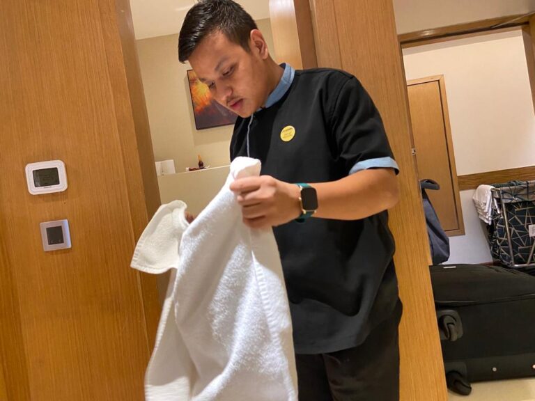 A hospitality trainee demonstrating linen handling during an ISM Ranchi housekeeping activity