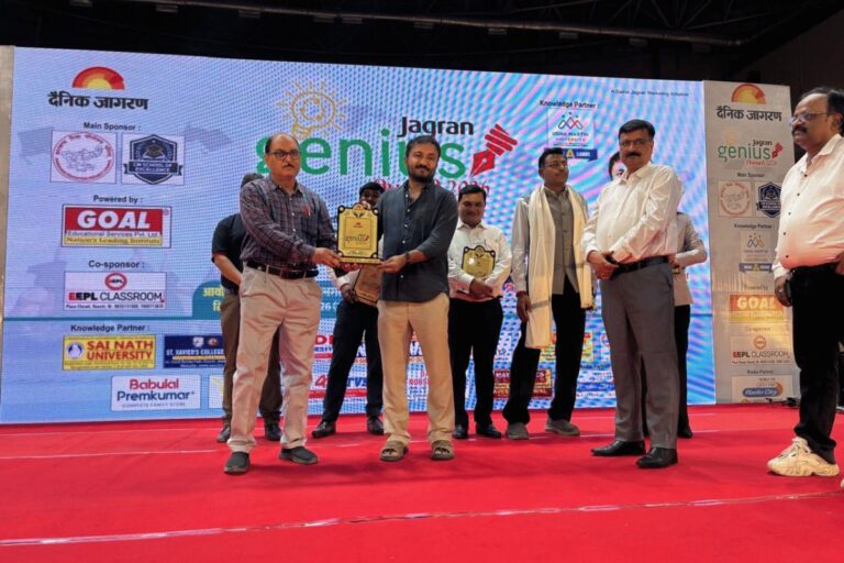 A student receiving an award from guests on an ISM Ranchi event stage