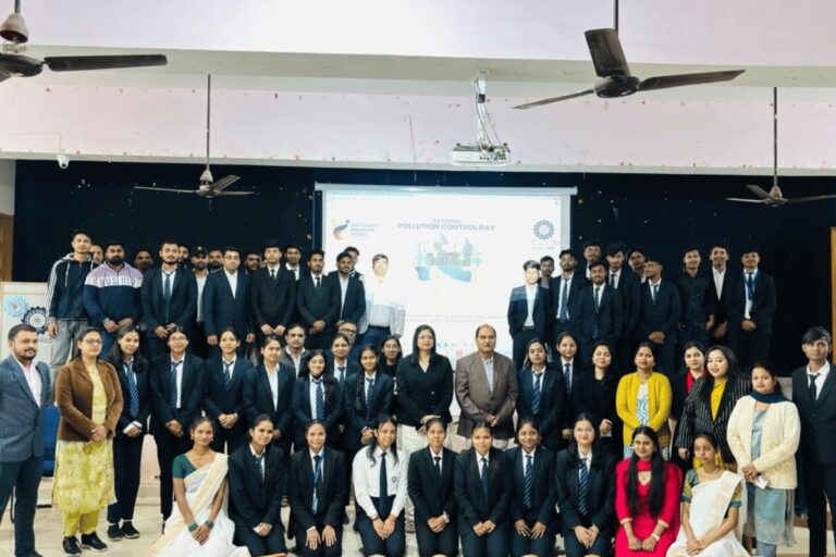 Students and guests posing together beside a presentation screen at ISM Ranchi